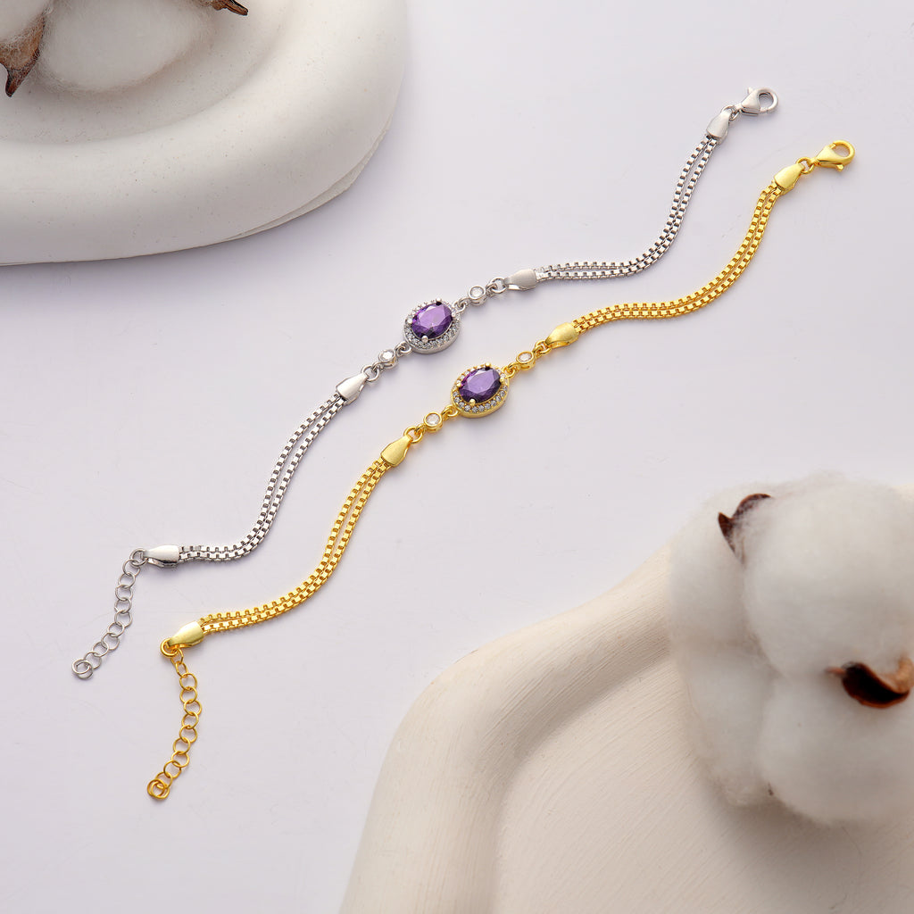 925 sterling silver and 14K gold plated bracelet featuring an oval amethyst color cubic zirconia centerpiece with halo clear CZ accents and an adjustable box chain.