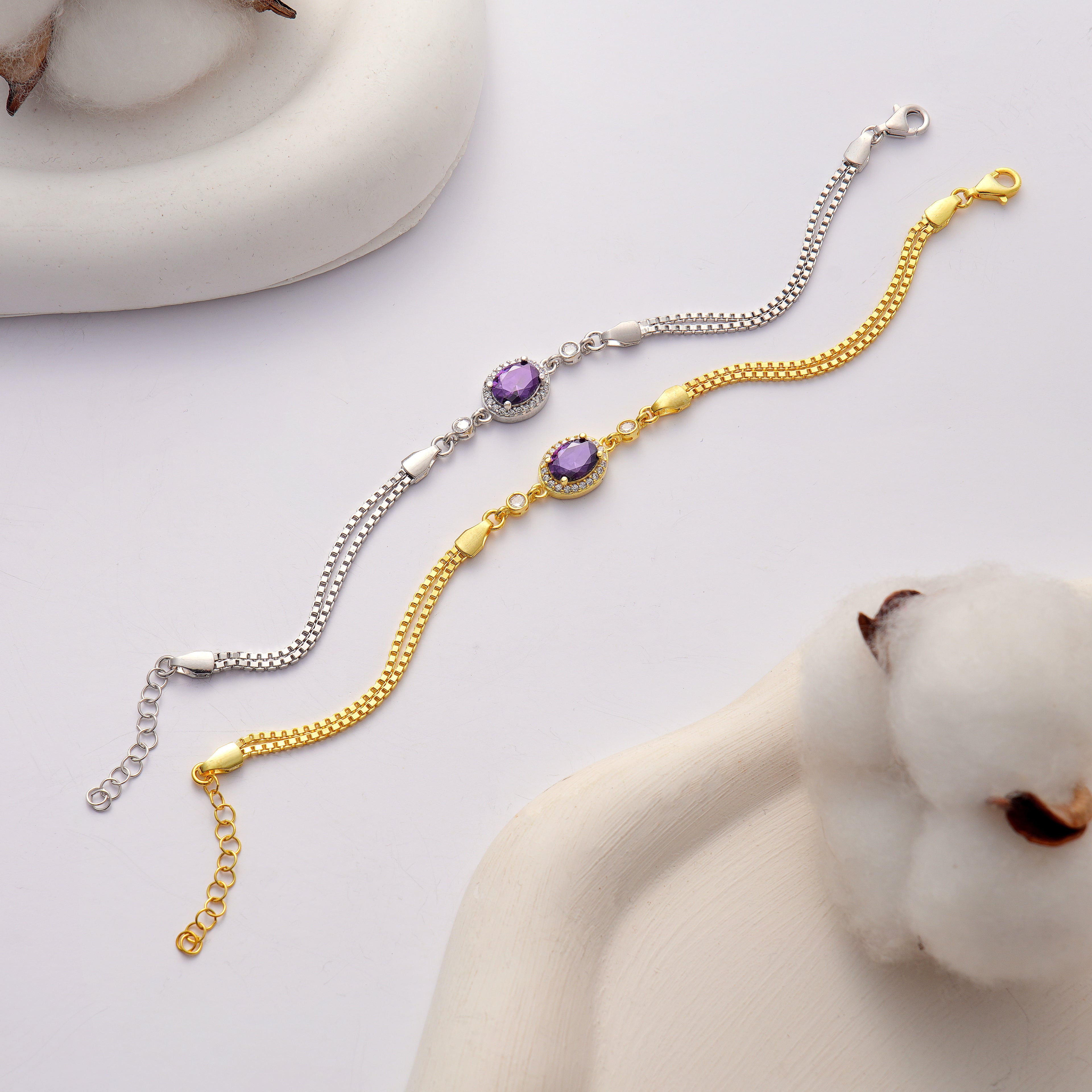 925 sterling silver and 14K gold plated bracelet featuring an oval amethyst color cubic zirconia centerpiece with halo clear CZ accents and an adjustable box chain.