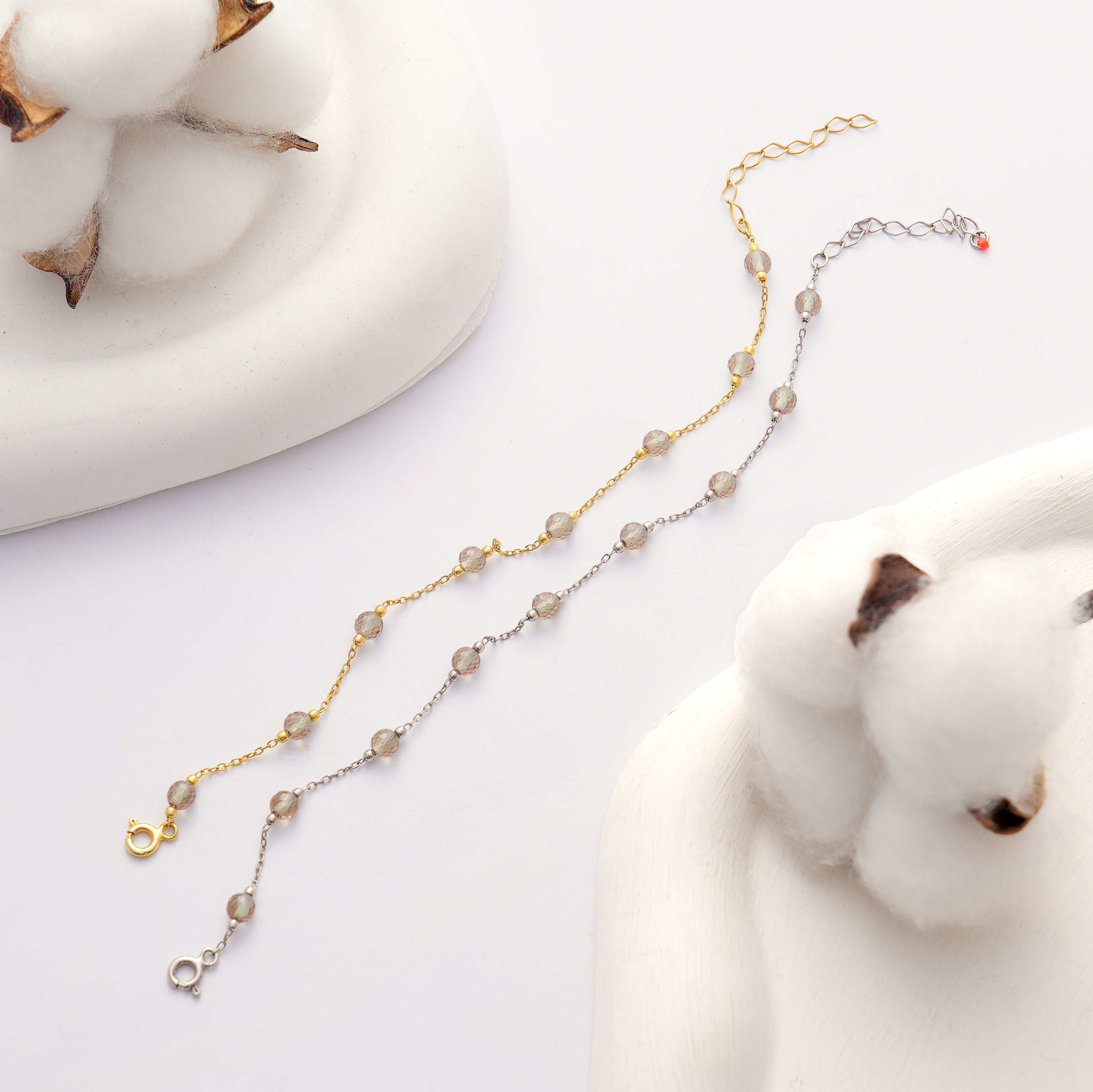925 sterling silver 14K gold plated bracelet featuring faceted color changing gemstones on a delicate chain displayed on a white background with cotton decor.