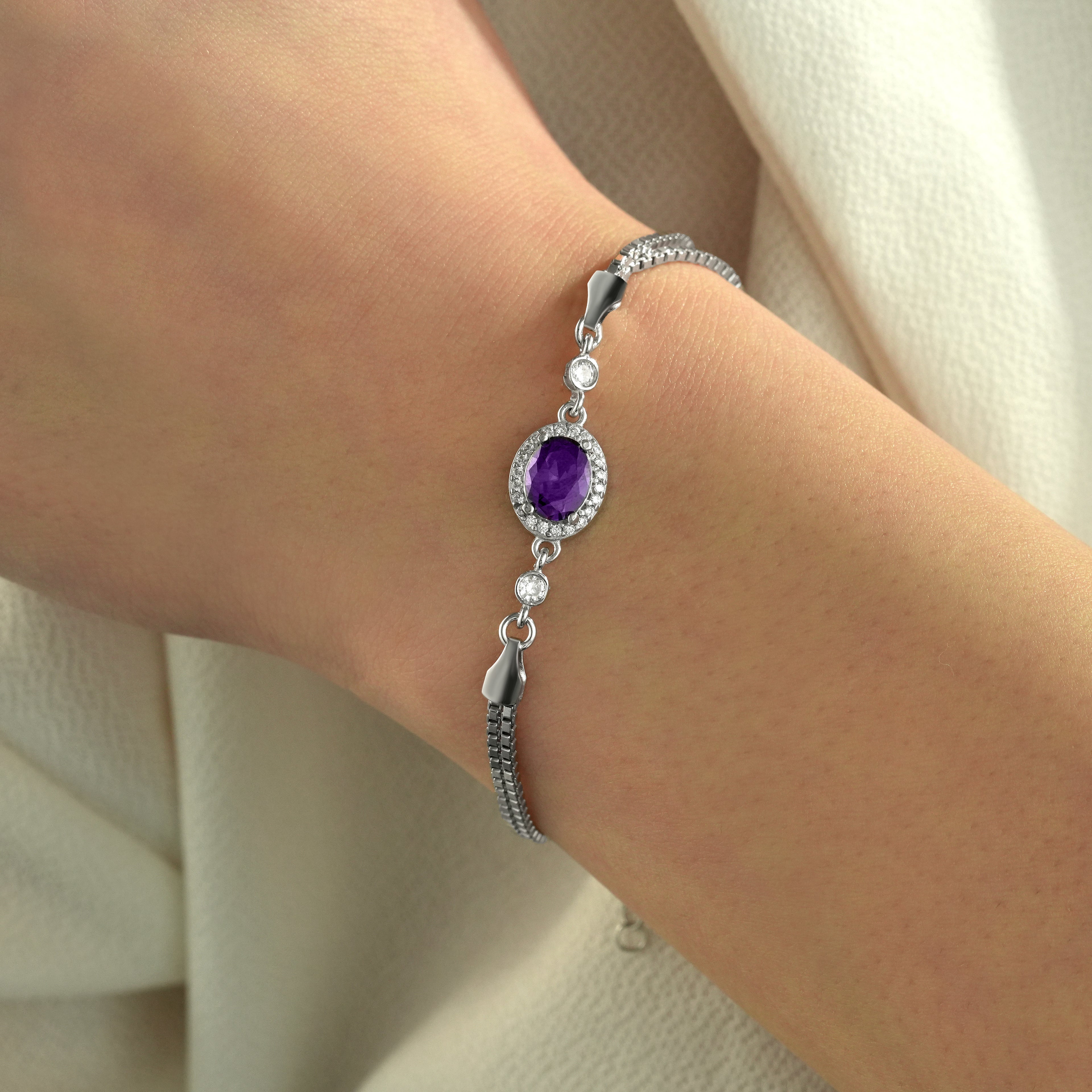 Elegant 925 sterling silver bracelet with an oval amethyst color cubic zirconia centerpiece worn on the wrist.
