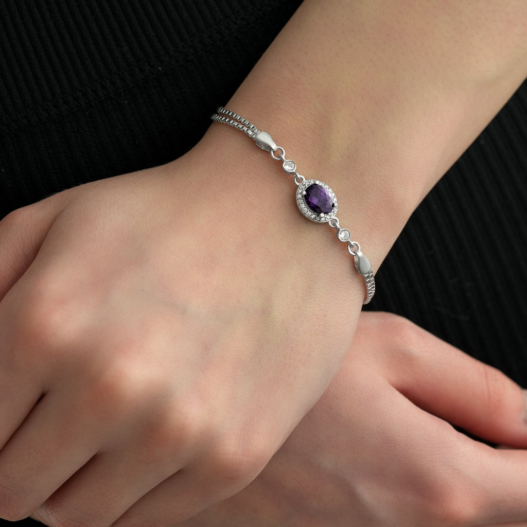 Close-up of a 925 sterling silver bracelet featuring an oval amethyst color cubic zirconia stone surrounded by clear CZ accents.