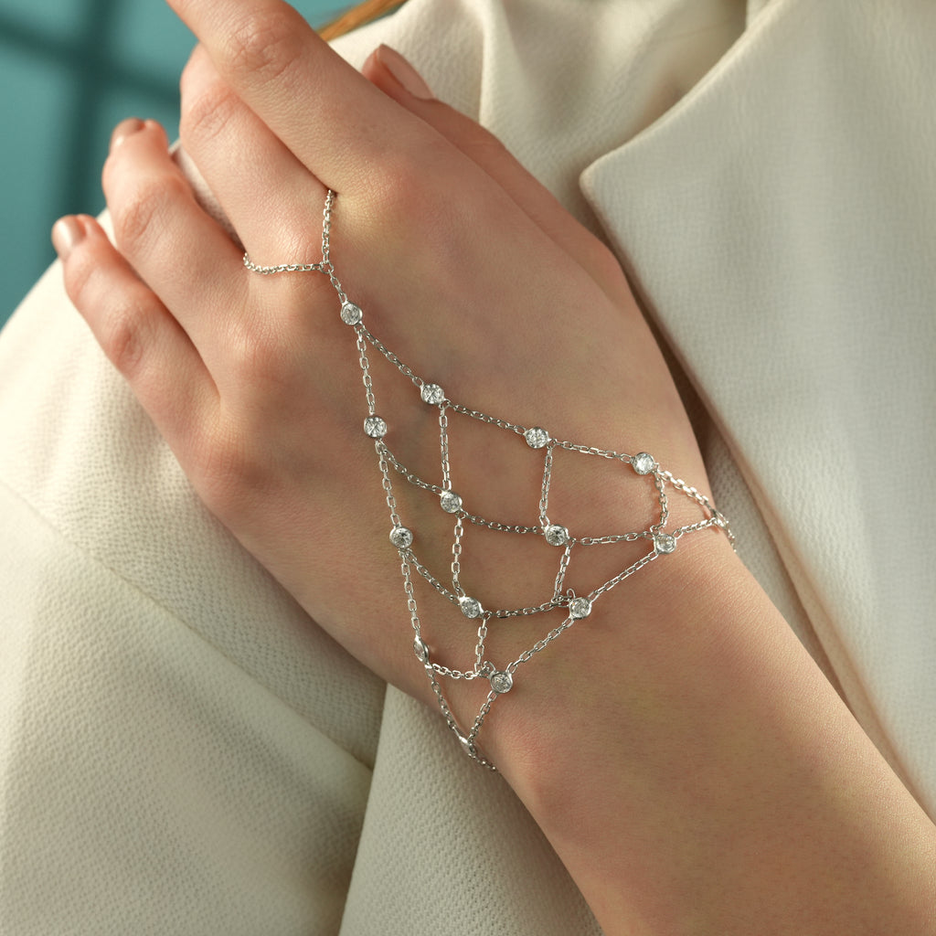 Woman wearing a 925 sterling silver hand chain bracelet featuring bezel-set cubic zirconia stones in an elegant layered chain design.