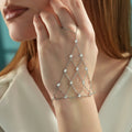 Woman wearing a 925 sterling silver hand chain bracelet with sparkling cubic zirconia stones and cascading layered chain details.