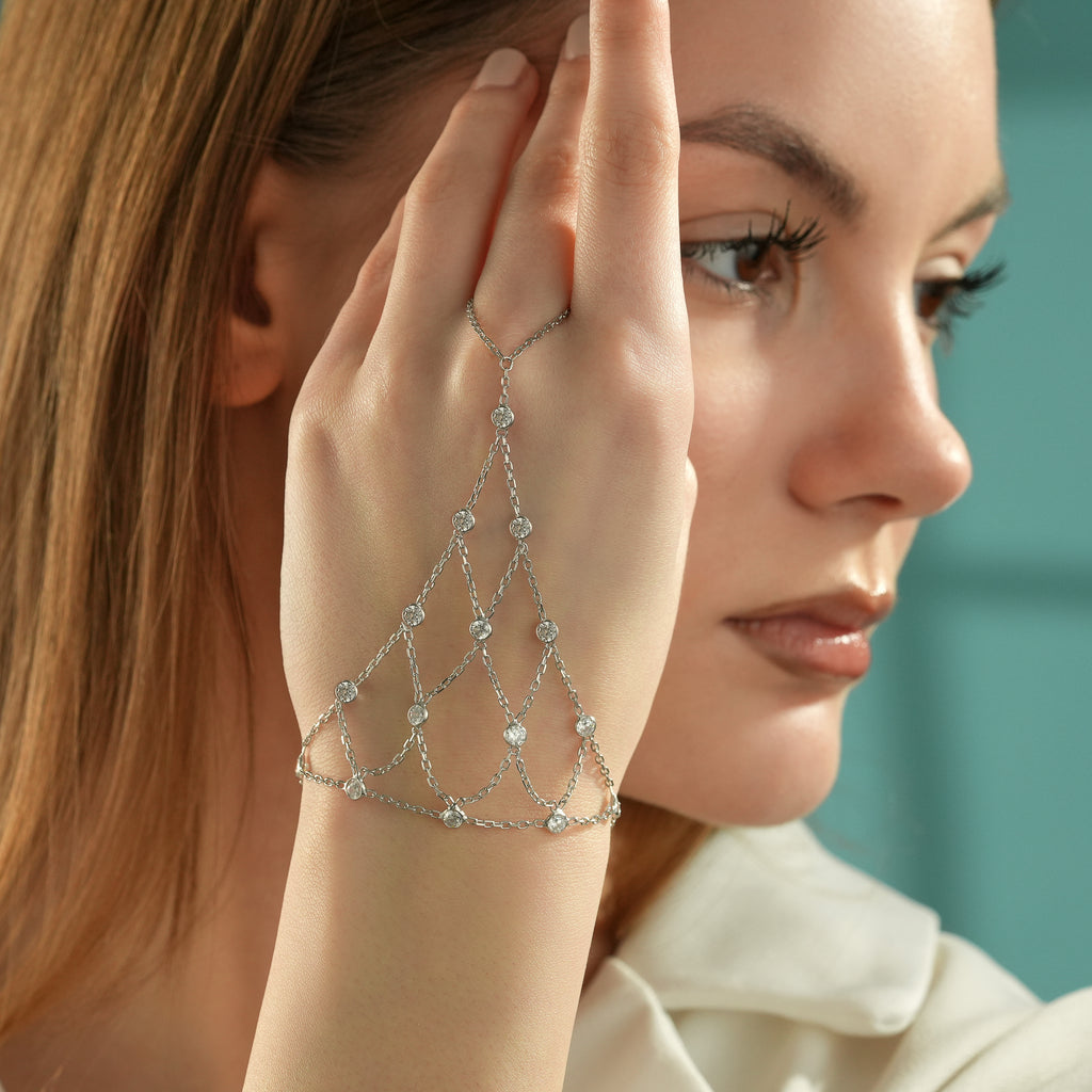 Close-up of a 925 sterling silver hand chain bracelet featuring multiple layered chains with bezel-set cubic zirconia stones.