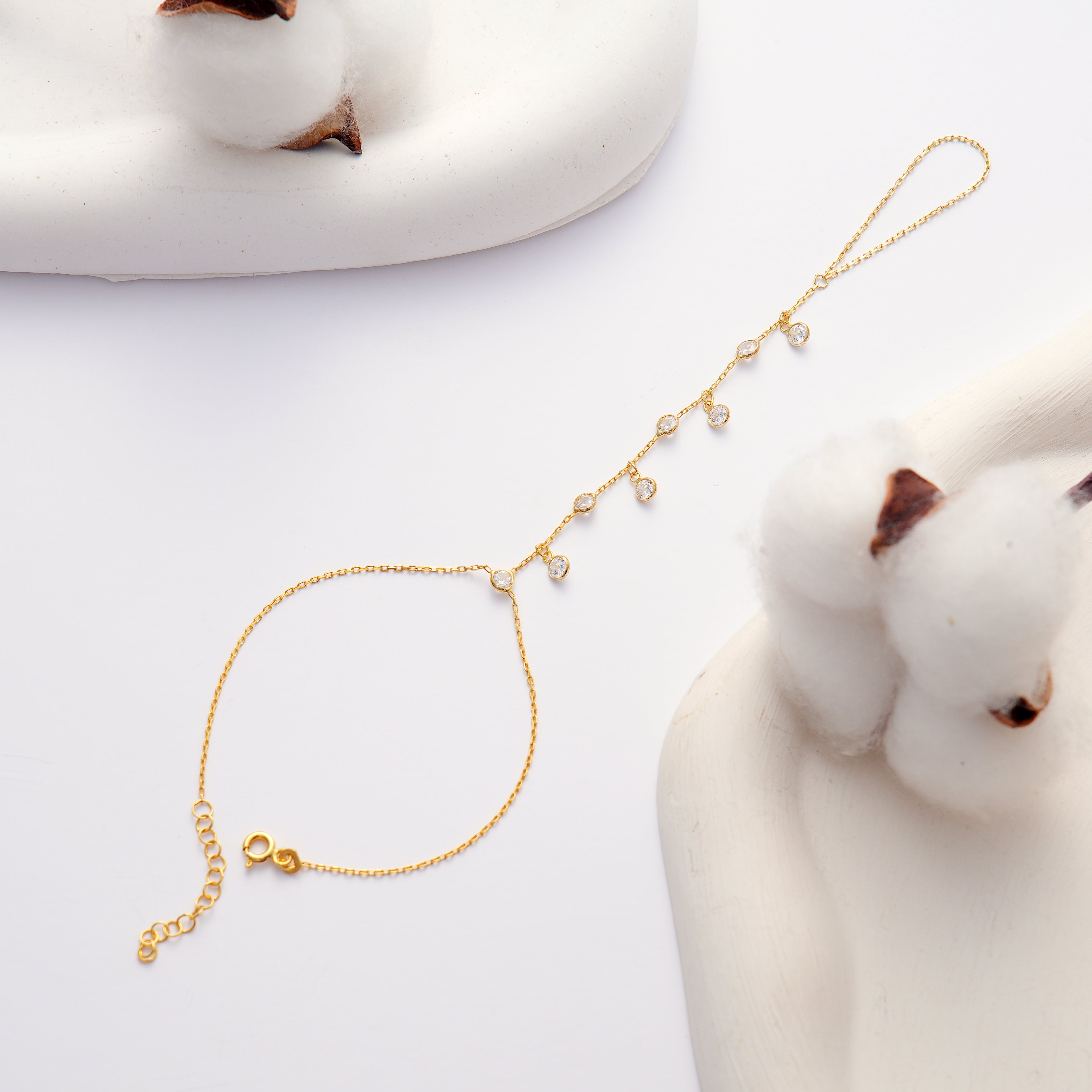 14K gold plated 925 sterling silver hand chain bracelet with dangling round clear cubic zirconia stones and an adjustable chain.