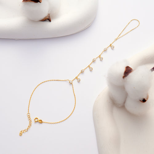 14K gold plated 925 sterling silver hand chain bracelet with dangling round clear cubic zirconia stones and an adjustable chain.
