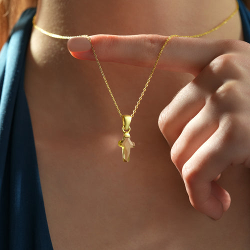 Close-up of a genuine natural color-changing diaspore cross pendant on a 14K gold plated sterling silver necklace.