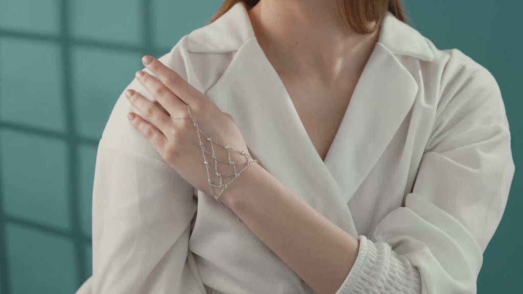 Video of Woman wearing a 925 sterling silver hand chain bracelet with sparkling cubic zirconia stones and cascading layered chain details.